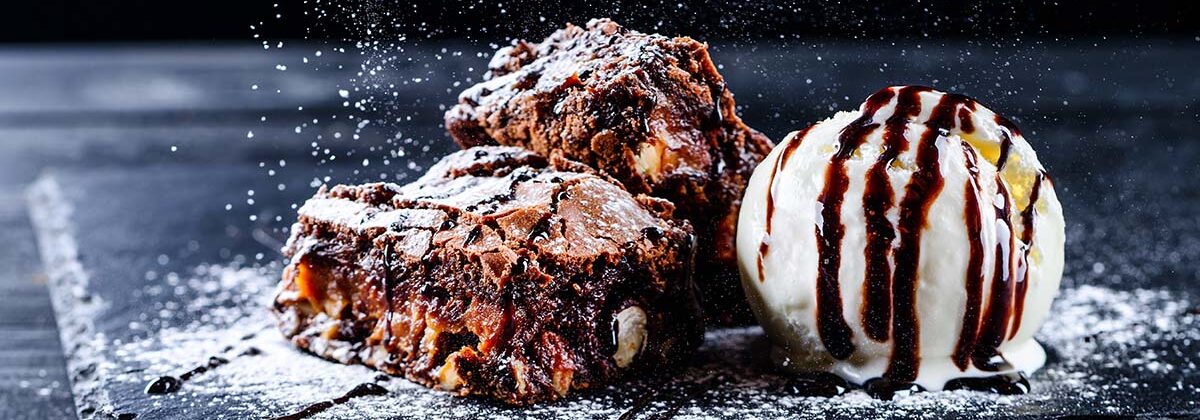 Brownie with ice cream and chocolate sauce representing a restaurant dessert used as an incentive to increase Sunday visits.